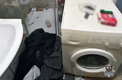 Schował się za pralką pod ubraniami